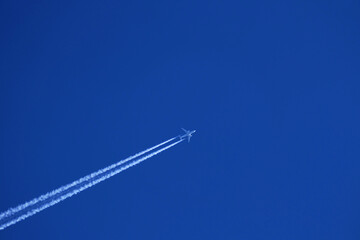 airplane trail in the clear blue sky - obrazy, fototapety, plakaty