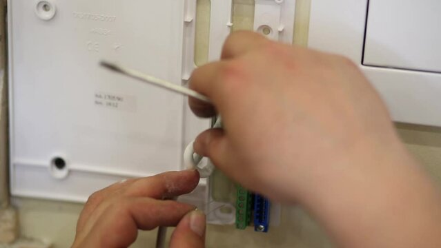 Male hands insert a jumper into the terminal block.