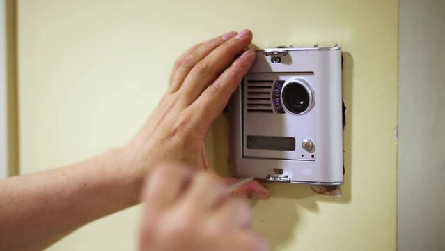 Worker mounts cover on external part of home intercom