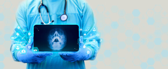 The doctor holds a tablet and examines an x-ray of paranasal sinuses, deviation of the nasal septum, localization of nasal polyps, shows the x-ray of the skull with waters projection - obrazy, fototapety, plakaty