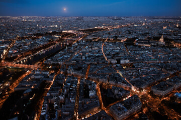 Paris city at night from above. Aerial view from Eiffel tower at blue hour. Panorama skyline after sunset. Full moon night at Capital of France