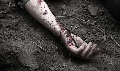 Hand of a wounded soldier on the ground