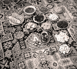 Eastern feast. Asian still life of dried fruits and nuts in plates on a carpet