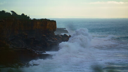 Fototapeta na wymiar Stunning waves crashing rocky coastline at dusk. Stormy ocean making explosion