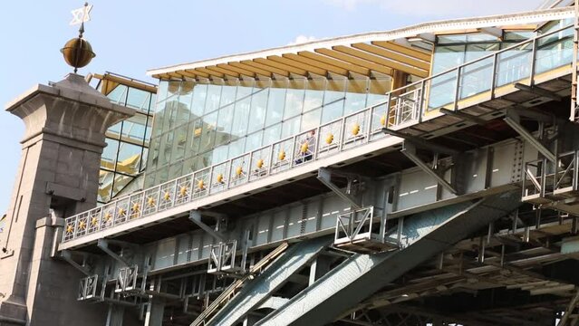 Under view of man going on footbridge with glass walls in city