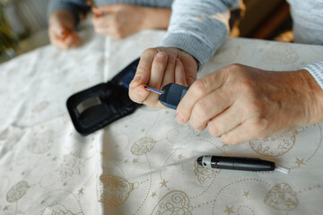 A man draws blood and checks his blood sugar level with a glucometer.