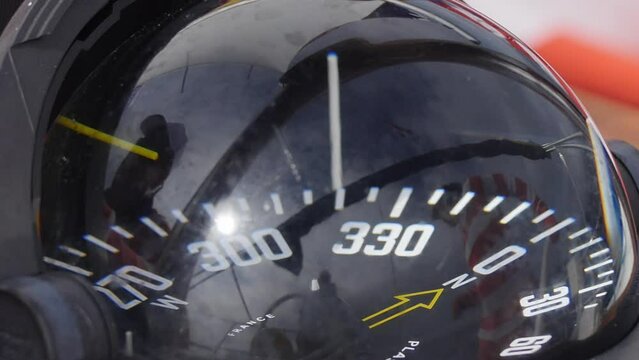 Close-up, yacht compass is functional equipment. Compass serves as an unwavering navigator, providing real time information about heading of boat.
