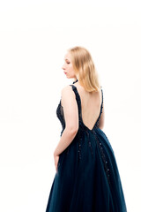 Naklejka premium Young blonde woman in a dark blue ball gown with a fluffy skirt on a white background
