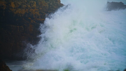 Violent ocean waves crashing wild cliff closeup. Seashore storm crashing rocks