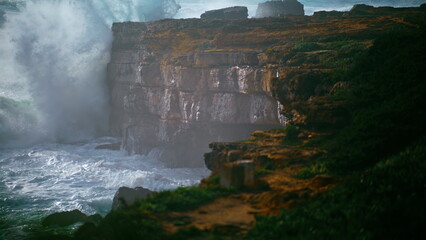 Fototapeta premium Storm surf breaking cliffs in super slow motion. Powerful waves breaking rocky
