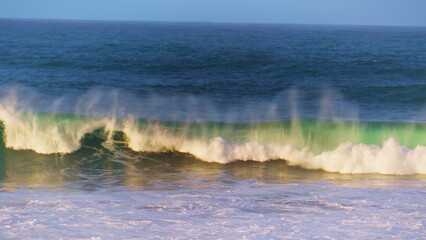 Morning ocean wave rolling towards shallow in super slow motion. White sea foam