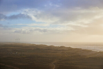 Fototapeta na wymiar Stormy northern sea at sunset in Denmark. Windmills on the horizon