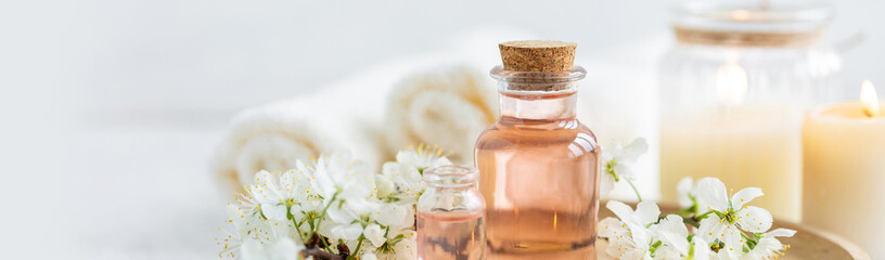 Aromatherapy, home decor concept. Glass perfume bottle, elegant composition with spring flowers....