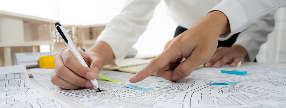 Worker, architect and engineer work on real estate construction project oratory planning with cartography and cadastral map of urban town area to guide to construction developer business plan of city