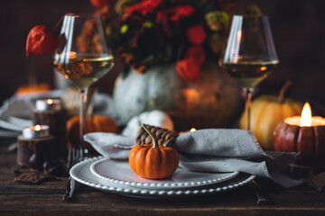 Fall composition. Orange pumpkins, flowers and candles on wooden table. Family elegant Thanksgiving...