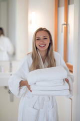 Young woman with towels smiling and looking contented