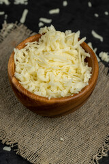 grated cheese for cooking in a wooden bowl in the kitchen