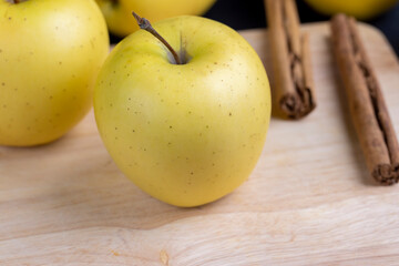 yellow ripe apple with cinnamon on the table