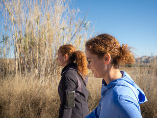 Two Red Hair Women Enjoying a Walk in Dry Grassland