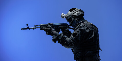 Soldier in black uniforms with weapon in studio. Concept Military warrior army tactical force to fight crime in city