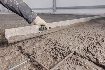 Process leveling floor after pouring cement. Construction site Worker use level for concrete of...