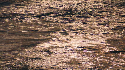 Shimmering water reflecting sunlight on summer day. Calm shining surface texture