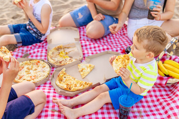 Family and Friends Enjoying Pizza Picnic on Beach