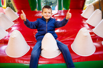 Fototapeta na wymiar Happy Boy Giving Thumbs Up on Playground Slide