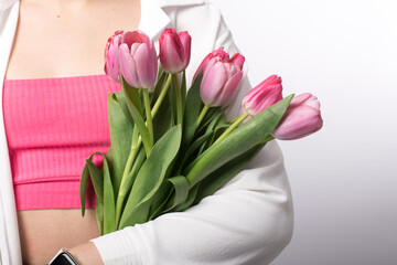 the girl holds a bouquet of pink tulips in her hands. spring flowers