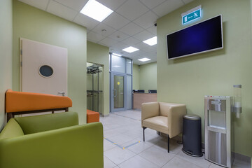The lobby of the clinic with an entrance door, a reception desk and a wardrobe. TV and .sofa for a pleasant wait.
