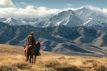 Foto op Canvas A horse wrangler riding solo on horse in mountains © Kateryna