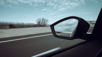 Left side window view scene of a road car on a highway on a beautiful forest landscape with sharp...