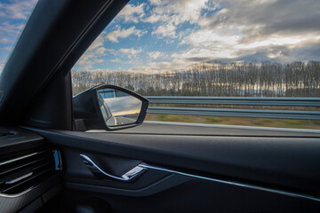 Right side window view scene of a road car on a highway on a beautiful forest landscape