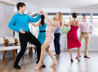 Adult woman and young man dancing in dance class