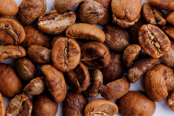 Macro fresh brown roasting coffee beans, warm light toning dark background