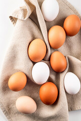 Chicken eggs on linen napkin on white background.