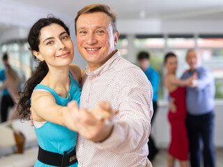 Adult man and young woman dancing in dance class