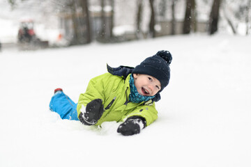 Fototapeta na wymiar Little Boy is Having Fun Playing With Snow