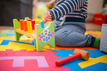 A baby entertained with a sensory game on the floor.