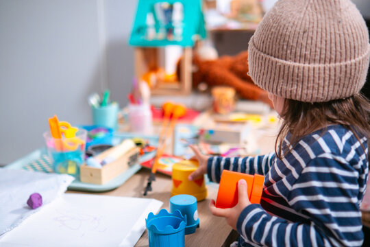 Ni&ntilde;a de dos a&ntilde;os jugando con bloques de pl&aacute;stico apilables 