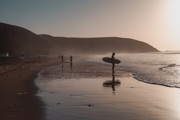 sunset on the beach with a surfer silhouette in Morroco.
