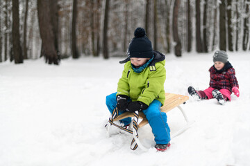 Fototapeta na wymiar Kids Having Fun on Sledding Playing in Snow