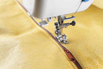 Modern sewing machine with yellow velours fabric. Sewing process clothes, curtains upholstery....