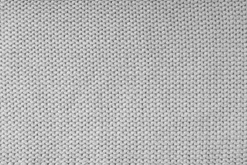 Close up background of knitted wool fabric made of viscose yarn, gray color wool knitwear texture. Sweater, pullover knitted jersey background. Fabric abstract backdrop, wallpaper