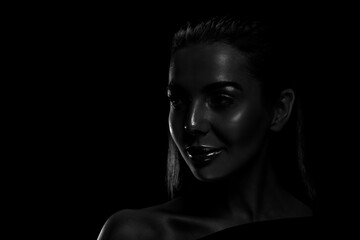 Silhouette of woman in darkness. Portrait on black background