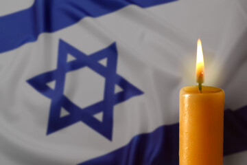 Burning candle against flag of Israel, closeup