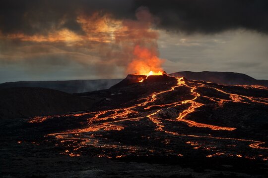 Lava spurting out of crater and reddish illuminated smoke cloud, lava flows, erupting volcano, Fagradalsfjall table volcano, Krysuvik volcano system, Reykjanes Peninsula, Iceland, Europe