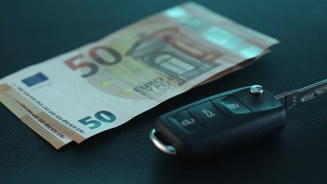 Hand Counts Money beside Car Keys. Close-up dolly shot with shallow dof.