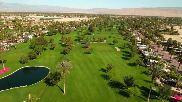 Aerial Beautiful View Of Mobile Home Park By Mountains In Desert, Drone Flying Forward Over Green Landscape On Sunny Day - Palm Springs, California