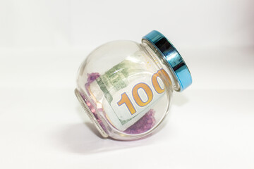 decorative jar containing $100 bills
